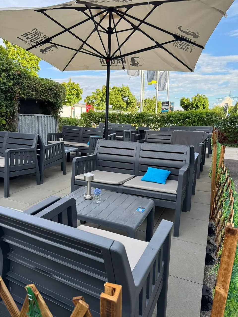 Lounge-Sofas mit blauen Kissen unter dem Sonnenschirm